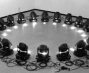 A kinetic installation.nAn array of moving heads displayed in a geometric configuration, a circle in this case, is programmed to deliver a choreography. The light shutter is opened with parsimony as the focus is put on the movements and the sounds of the motors: central are the moving heads themselves rather than the light patterns produced. nInstead of hidden in the scene in this situation the moving heads become the protagonists.nFor this first prototype twenty smaller moving heads were used.