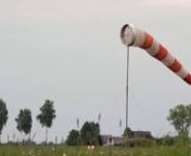 A windsock in an airport measuring wind speed and wind direction. It is a is a conical textile tube painted in white and orange stripes. A countryside is seen in a background.nnDOWNLOAD LINK: http://unripecontent.com/2015/05/26/airport-windsock-free-hd-video-footage/nnDimensions: 1920 x 1080nVideo codec: H.264nColor profile: HD (1-1-1)nDuration: 00:13nFPS: 25