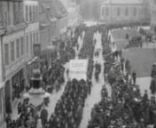 Demonstrationståg i Göteborg den 1 maj 1917. Sekvensen filmad från Kungsgatan 22 över Kaserntorget, Engelska kyrkan i fonden. Tåget, med standar såsom